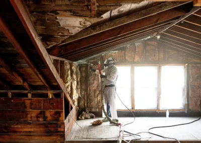 technician-applying-polyurethane-foam-to-wooden-rafter-cavities